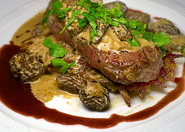 Rindersteak auf Rösti, unter Morchelragout, an Portweinsauce